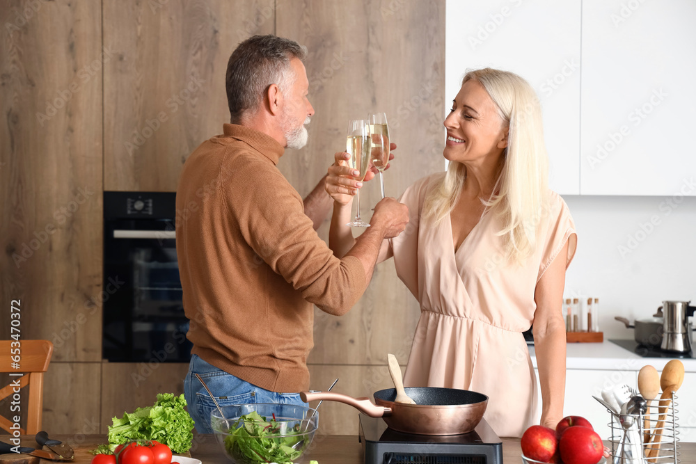 Mature couple drinking champagne in kitchen