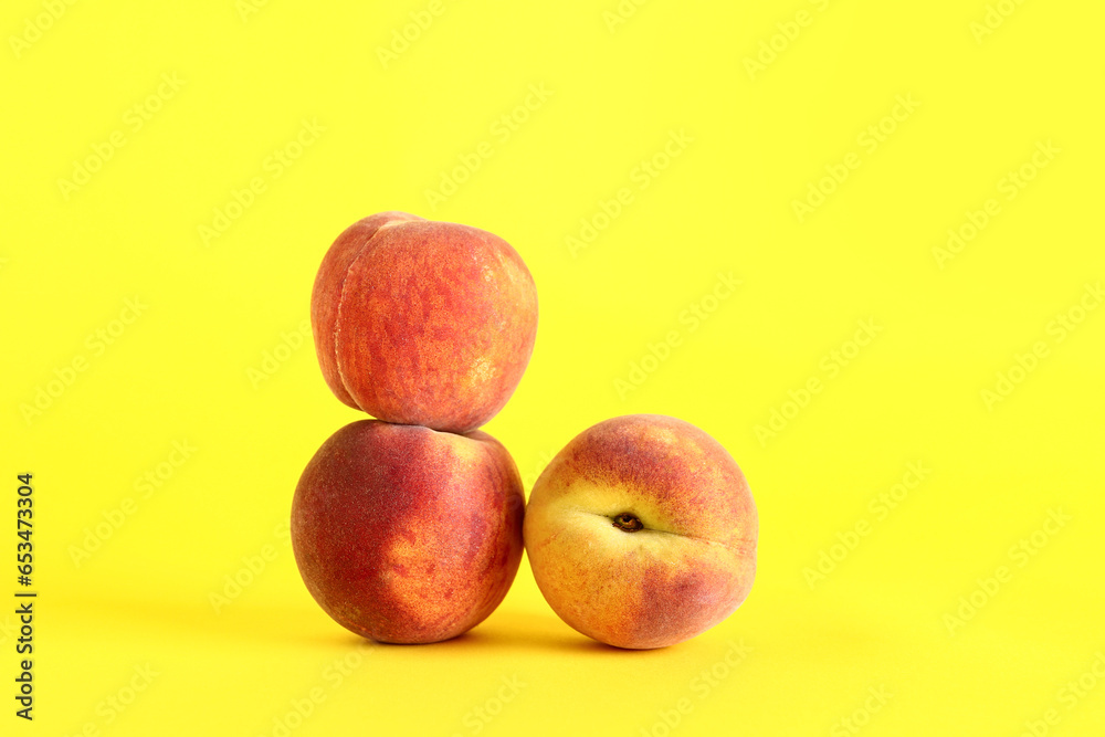 Sweet peaches on yellow background