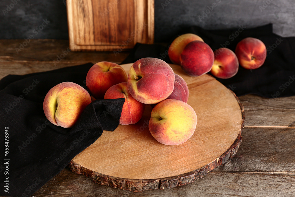 Board with sweet peaches on wooden table