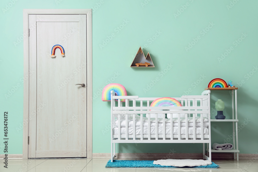 Interior of childrens room with crib near turquoise wall