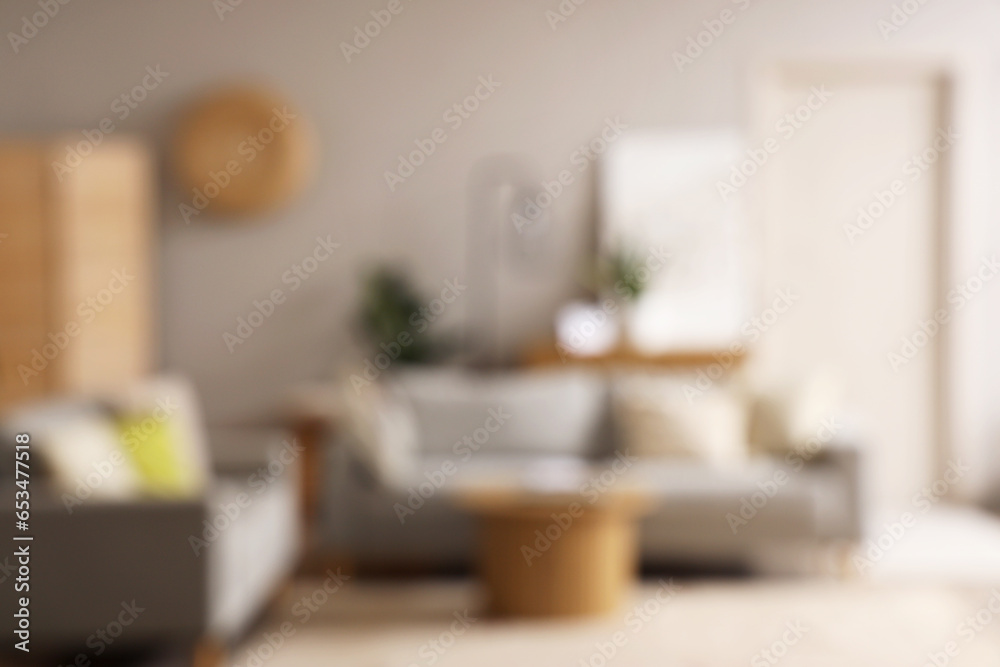 Blurred view of living room interior with grey sofas and coffee table