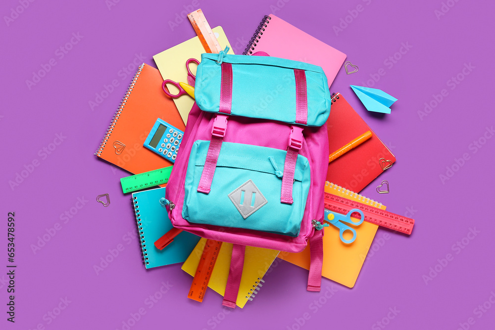 Stylish school backpack and different stationery on purple background