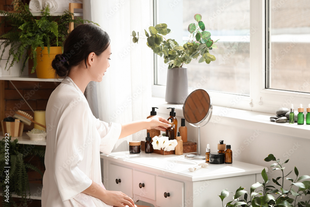 Beautiful Asian woman at dressing table in bathroom