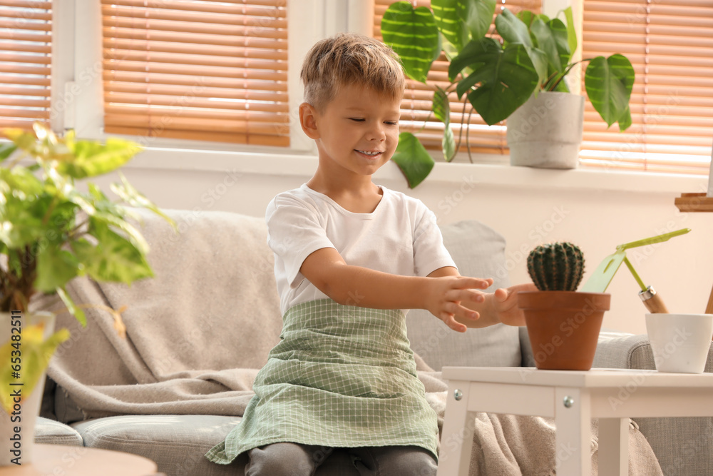 Cute little gardener with cactus at home