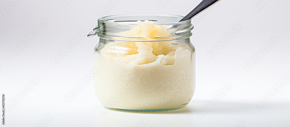 Baby pureed in jar on white background using a spoon