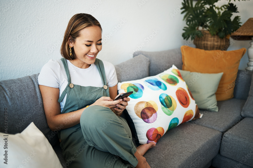 Woman, phone and happy in living room with relax for social media, communication and technology in home. Person, smile and happiness on sofa with internet, conversation and streaming entertainment