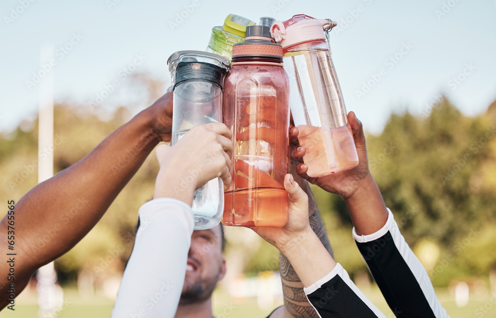 Hands, water bottle and cheers for team sports exercise, fitness or training outdoor on grass field. Diversity sports people, healthy cardio workout and goals in sun as athlete, motivation or support