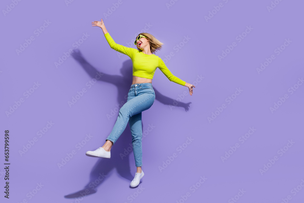 Full length photo of optimistic lovely girl wear stylihs clothes celebratig summer holidays solated on purple color background