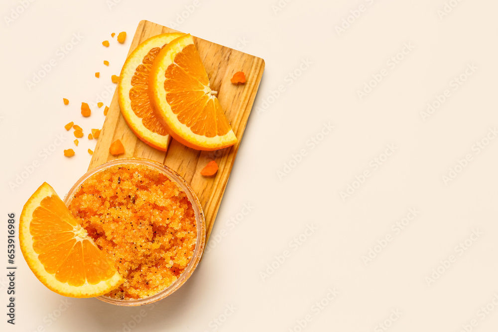 Wooden board with jar of natural body scrub, sea salt and orange slices on light background