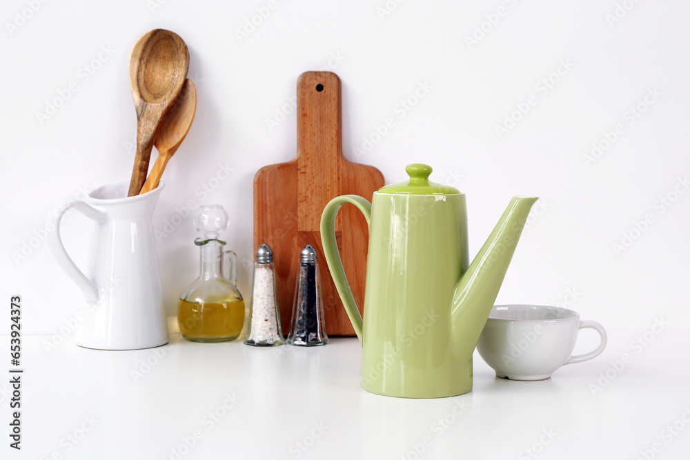 Composition with teapot, cup and different items on white table