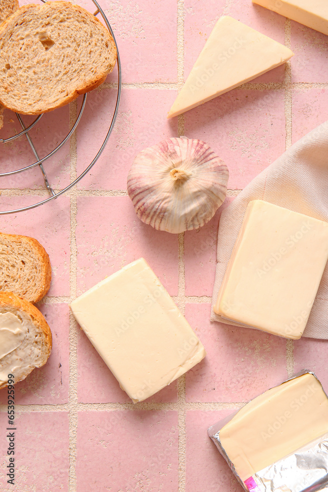 Processed cheese, bread and vegetables on pink tile background