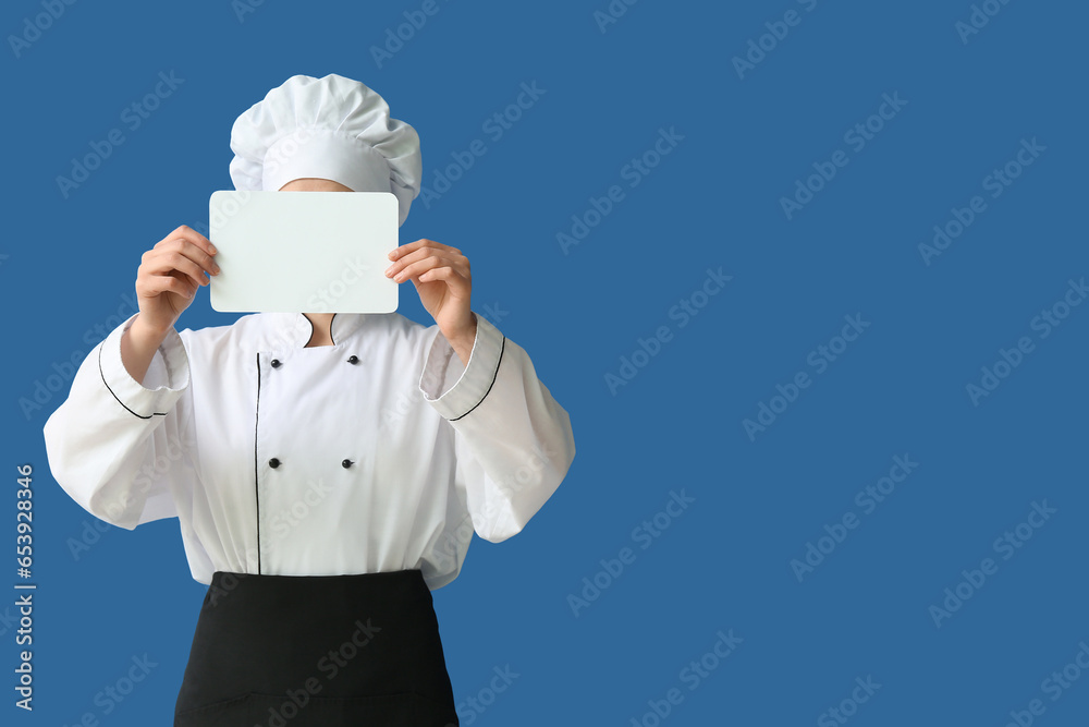 Female chef holding blank card on blue background