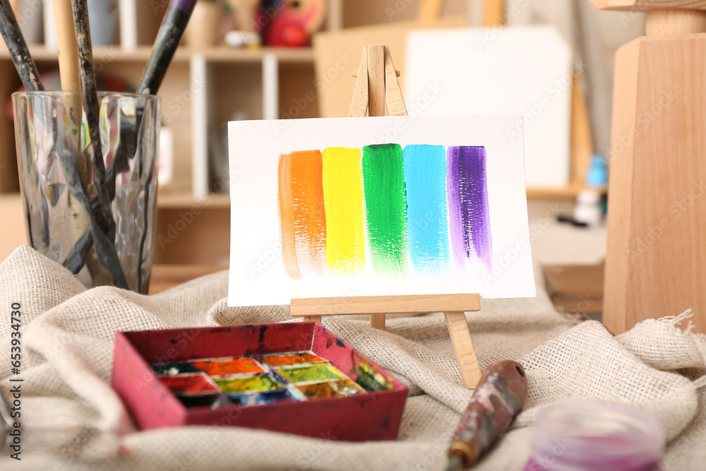 Mini easel with paints strokes in artists studio