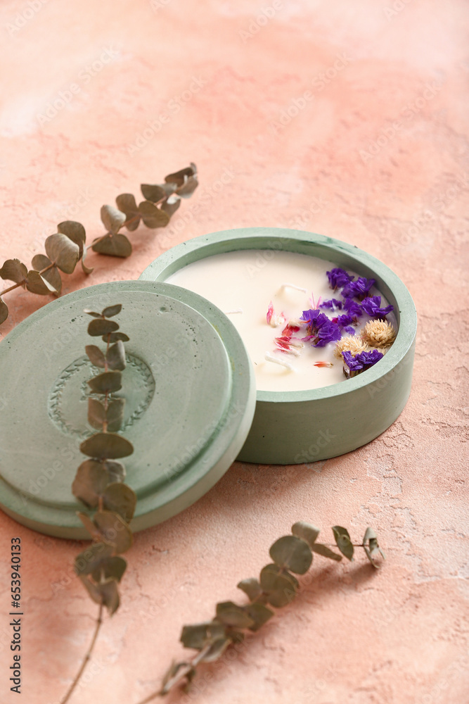 Holder with candle and eucalyptus on pink background