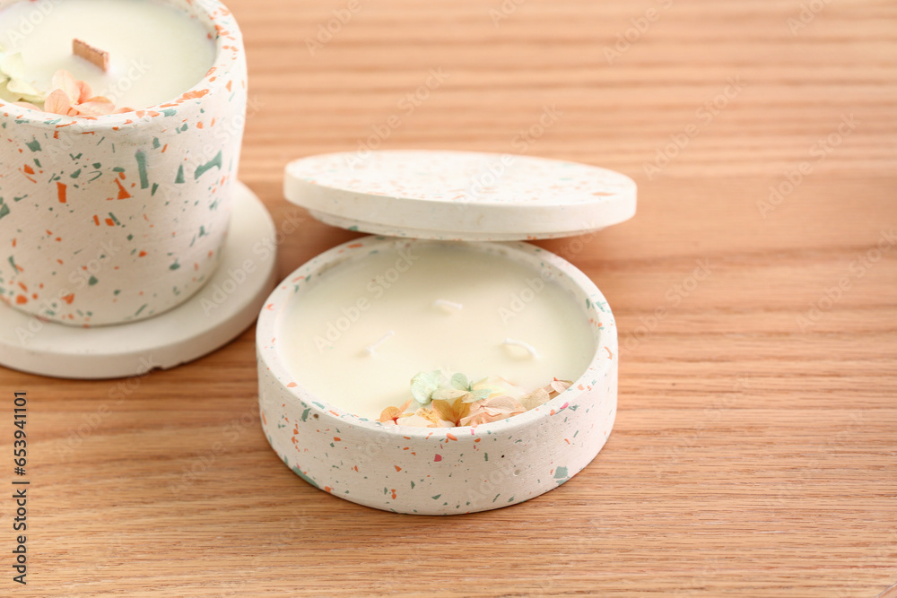 Holders with candles on wooden background, closeup