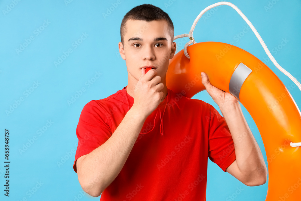 Male lifeguard with ring buoy whistling on blue background