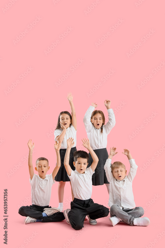 Happy little school children on pink background