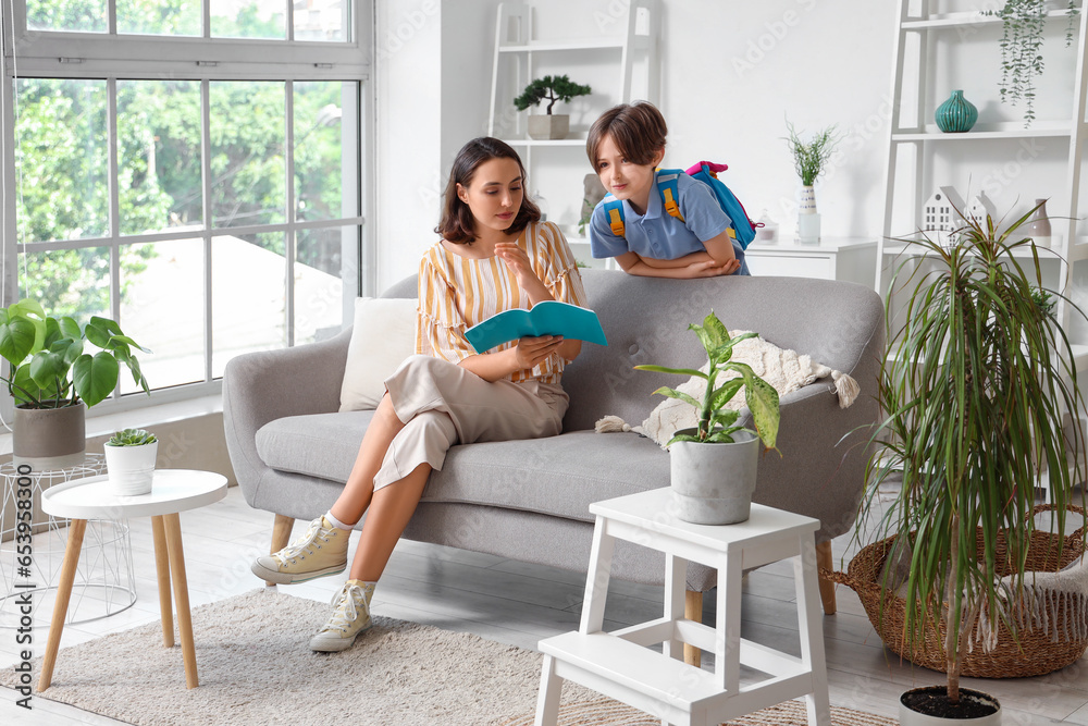 Mother helping her little son with homework at home