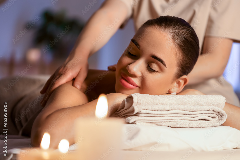 Pretty young woman having massage in spa salon