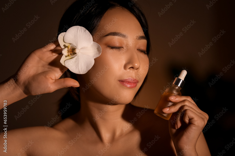 Pretty young Asian woman with essential oil in spa salon