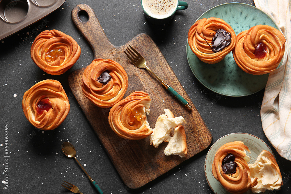 Tasty cruffins with chocolate and jam on black background