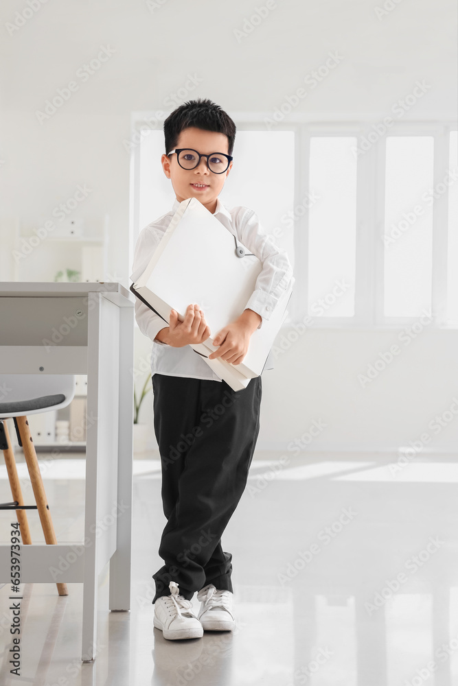 Cute little businessman with folders in office