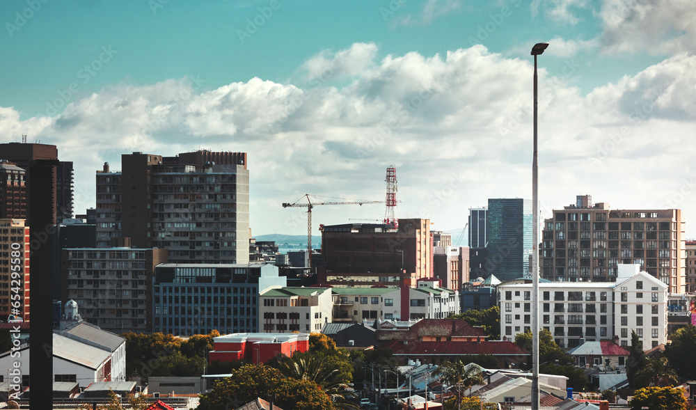 City, buildings and skyscraper with landscape for urban infrastructure or architecture outdoor in nature. Development, town and skyline with cityscape, tower and hotel for modern exterior and clouds