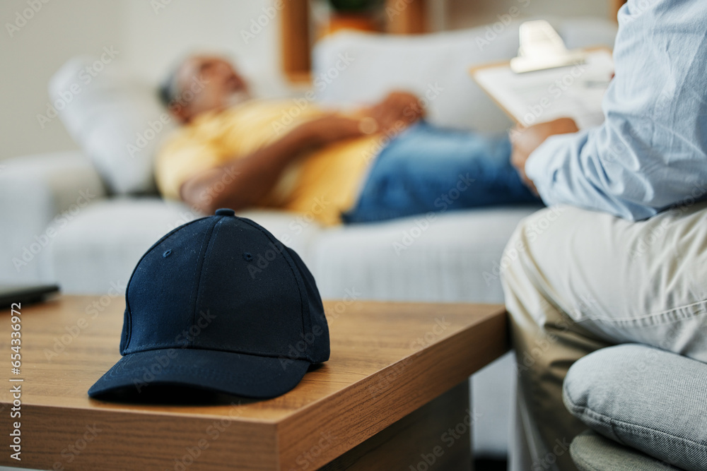 Cap, help and man in therapy for stress, conversation and discussion about mental health. Anxiety, psychology and closeup of hat on table in counseling for advice, notes or support from psychologist