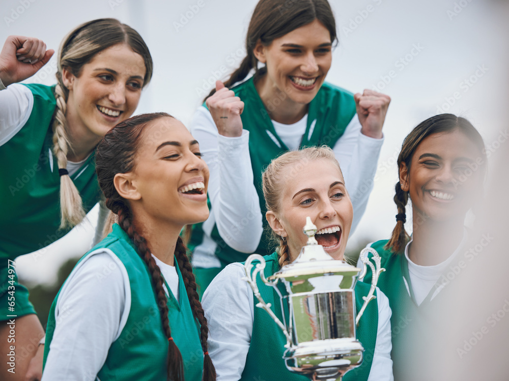 Sports women, team and trophy in celebration, winning and fist in air for competition on field. Champion girl group, friends and diversity for hockey, goals and happy outdoor at arena for contest