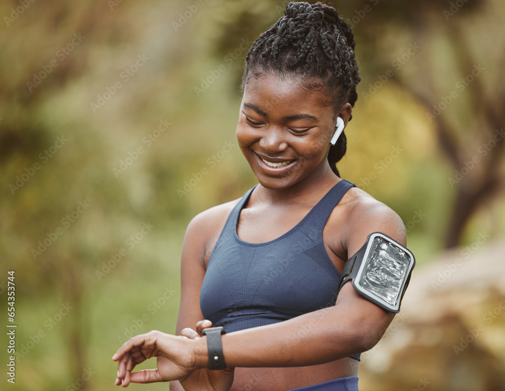 Fitness, smart watch and woman tracking performance on outdoor exercise, workout or training in a forest. Heart rate, wellness and young black person ready and listening to music, audio or podcast