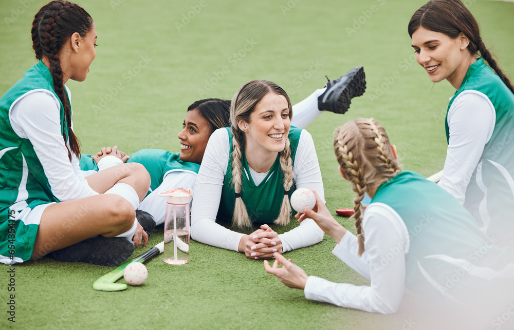 Women, team and hockey player on field, talking and relaxing after match, smile and workout. Conversation, happiness and positive for sports, fitness and exercise together for unity, game and health