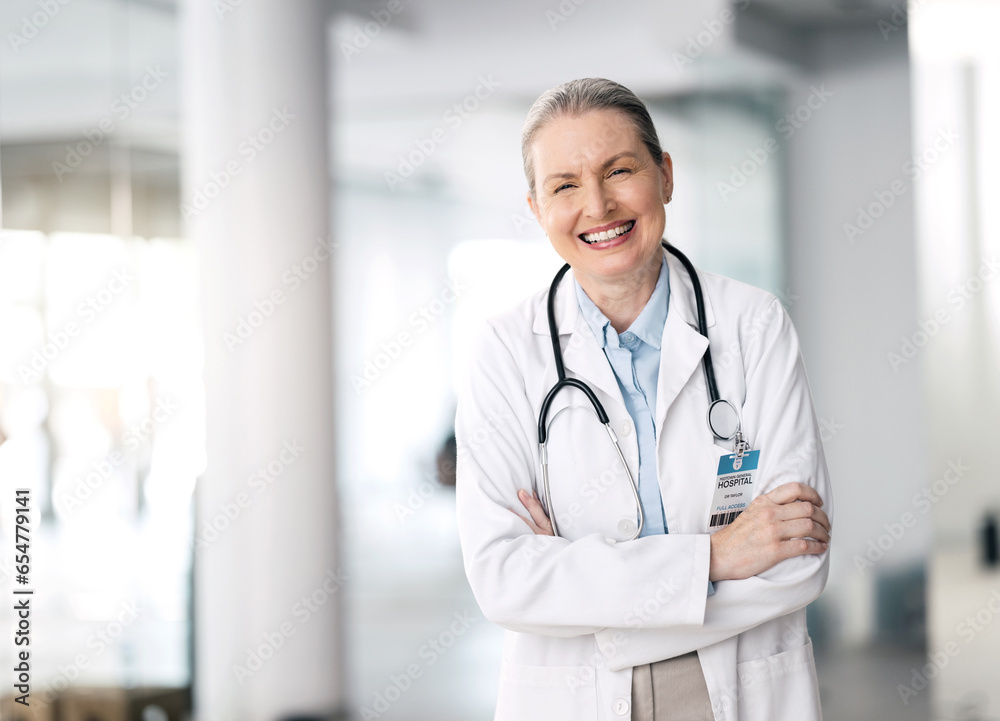 Doctor, woman and happy with arms crossed in hospital, standing and smile for medicine. Mature, person and healthcare for research, treatment or surgery with specialist in cardiology with stethoscope