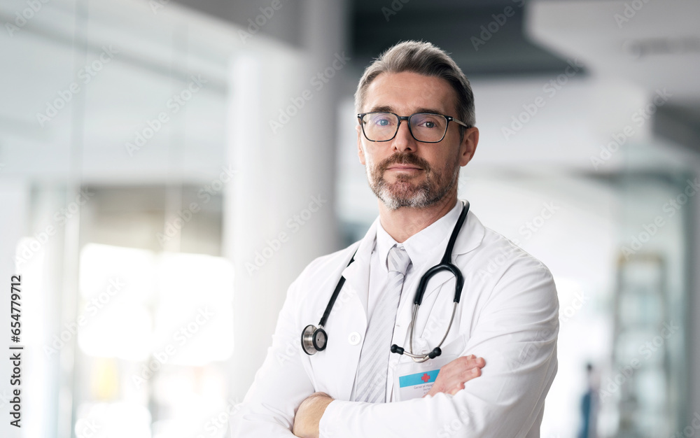 Serious doctor, portrait and man with arms crossed in hospital for healthcare, wellness or career. Face, medical professional and confident surgeon, expert and mature employee in glasses in Canada