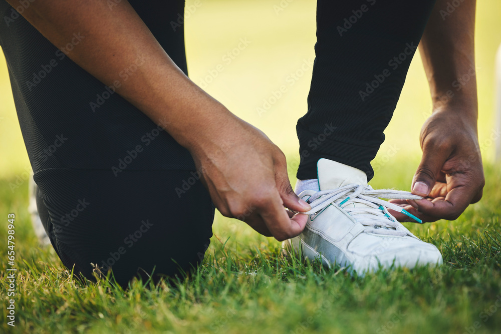 Person, hand and shoes for competition in sports on field for workout, practice or game in closeup. Athlete, dedication or tie lace on track for race by commitment in tournament, performance or match