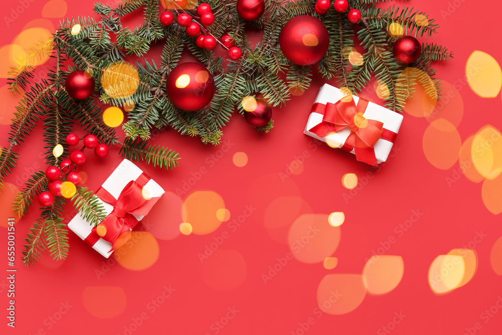 Christmas gifts, fir branches and decor on red background with space for text