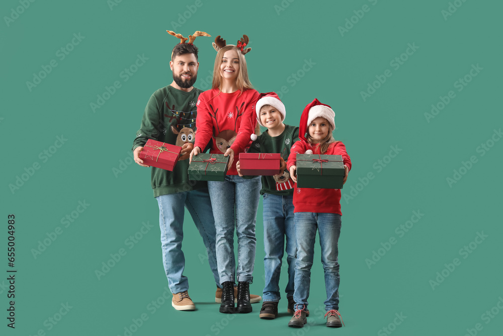 Happy family with Christmas gifts on green background