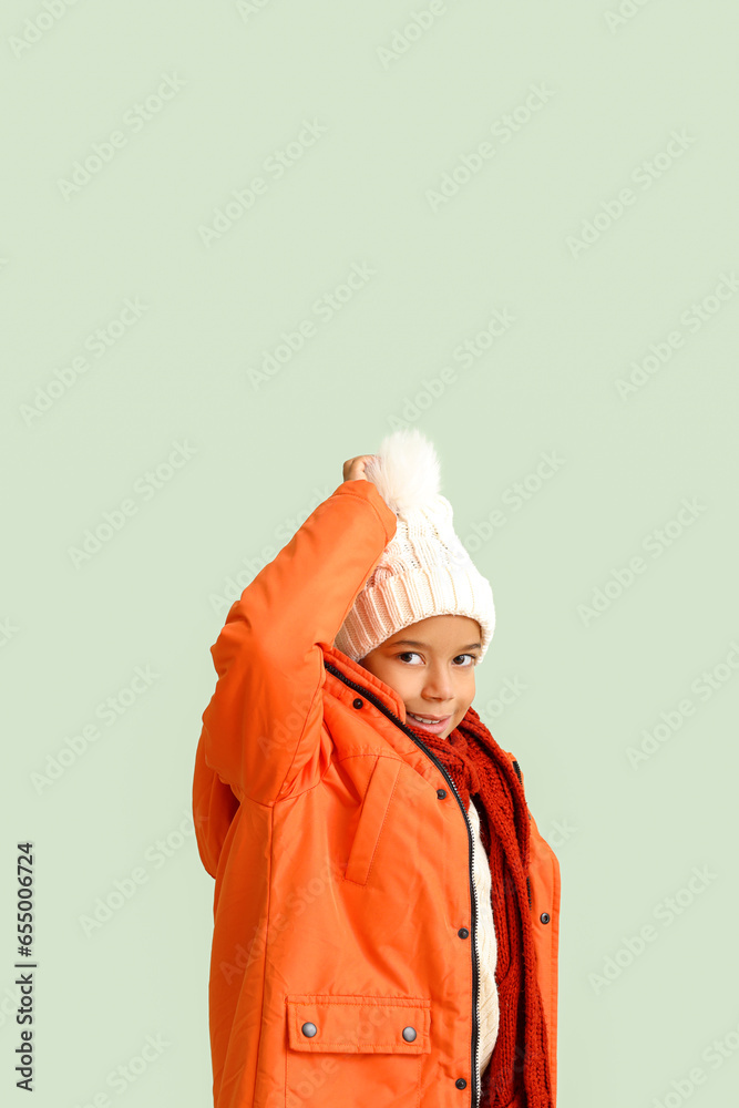 Cute African-American boy in warm winter clothes on light background