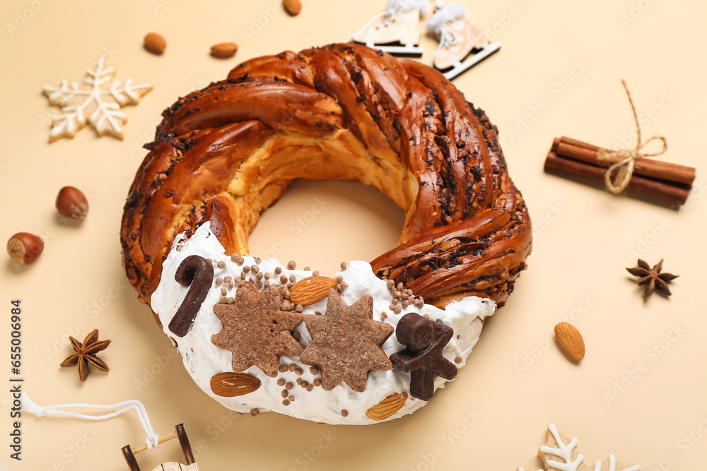 Tasty Christmas pastry wreath with spices, nuts and cookies on beige background