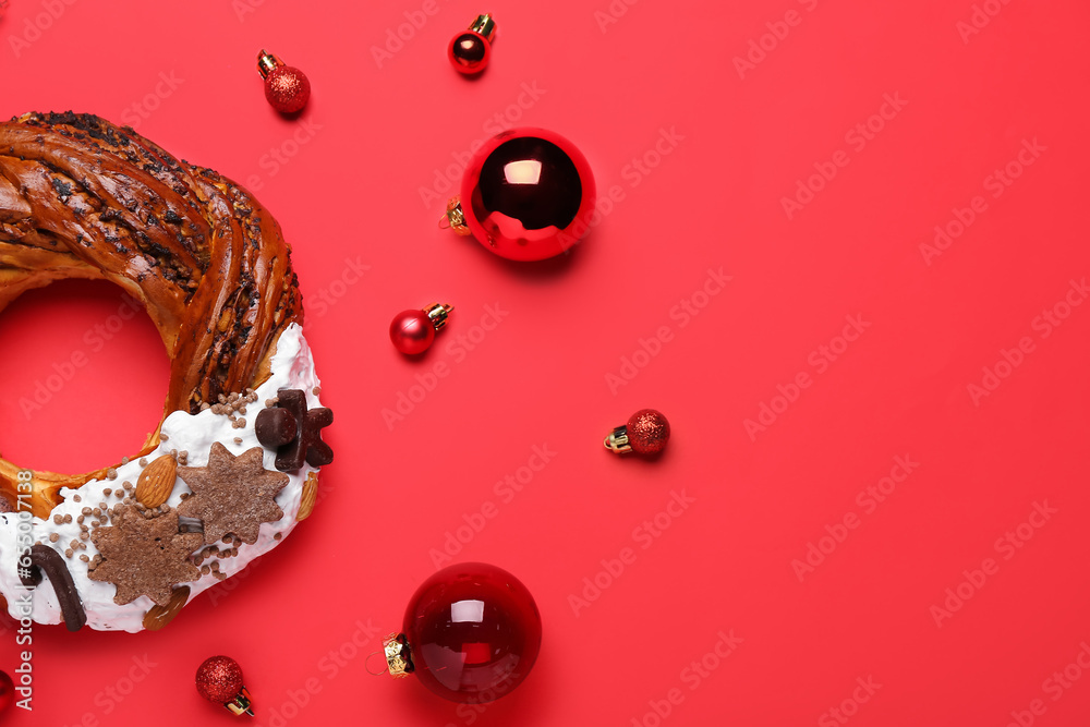 Composition with tasty Christmas pastry wreath and balls on red background