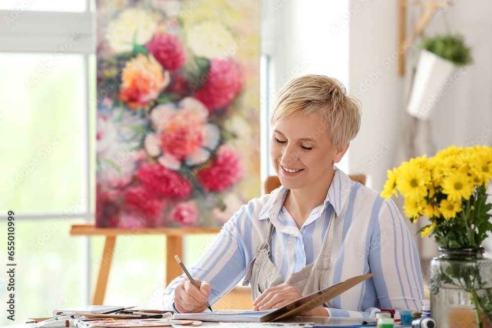 Mature female artist drawing sketch in  workshop