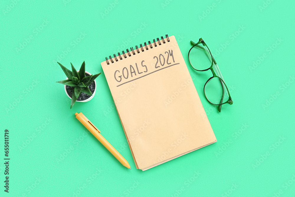 Notebook with empty to do list, eyeglasses and houseplant on green background. New year goals