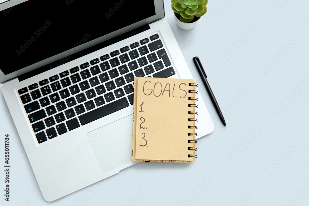 Notebook with empty to do list, laptop and houseplant on white background. New year goals