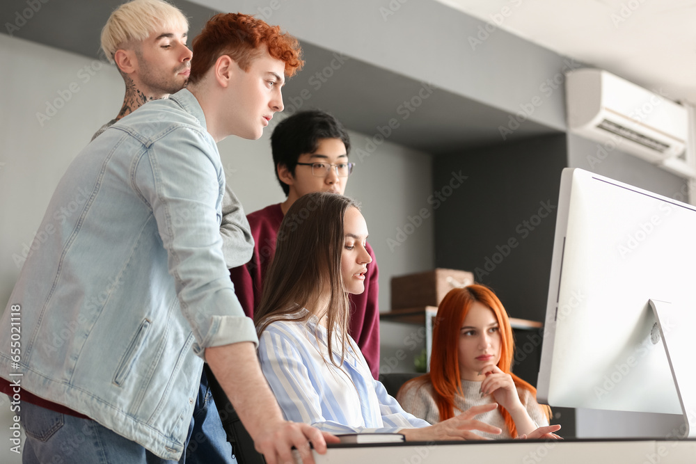 Team of young programmers working with computer in office