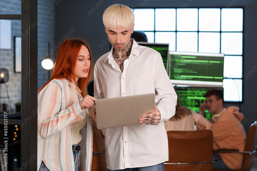 Young programmers working with laptop in office