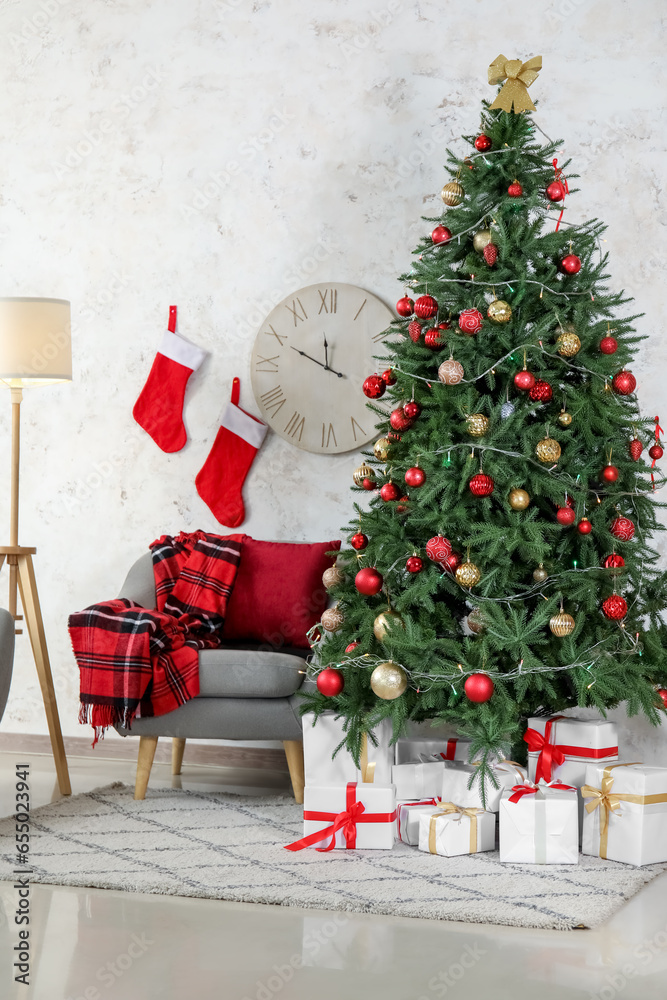 Interior of living room with grey armchair, Christmas tree, gift boxes and socks