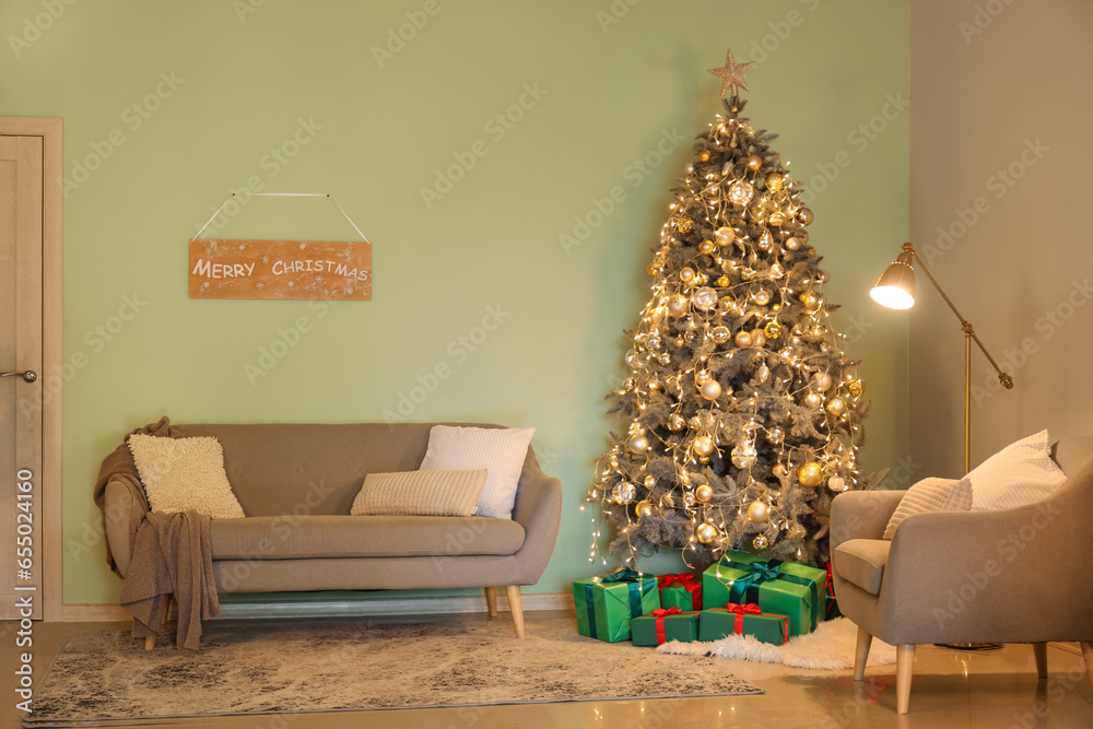 Interior of living room with Christmas tree, glowing lights, grey sofa and gift boxes