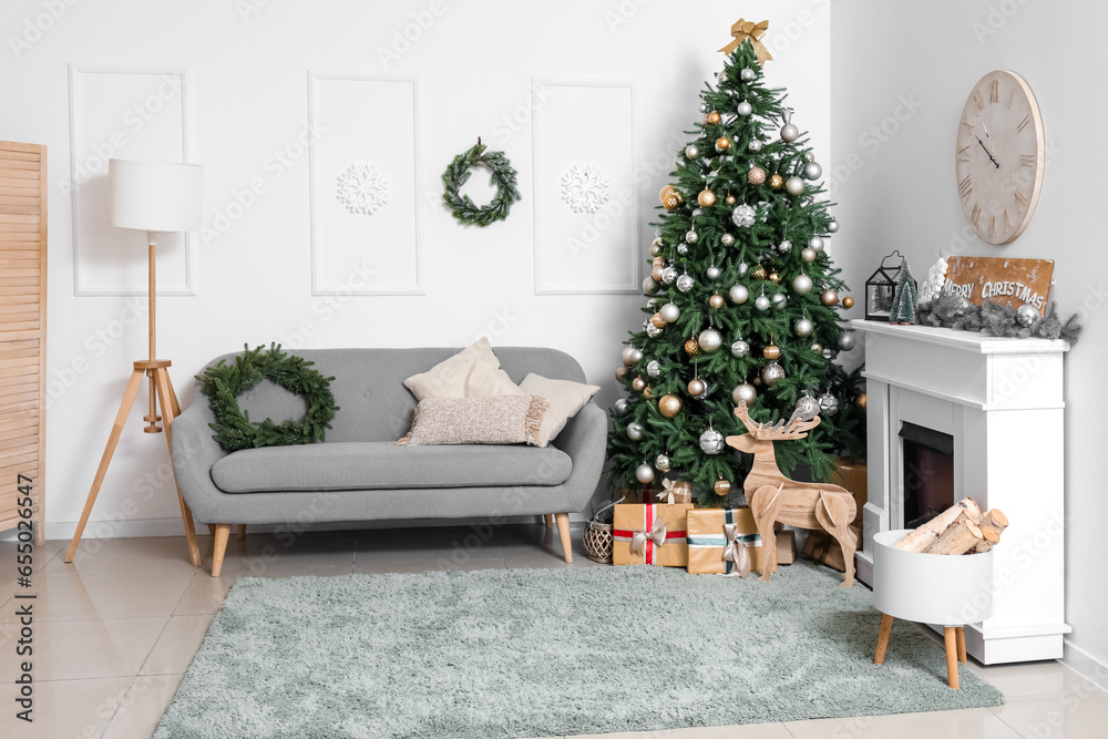 Interior of living room with Christmas tree, grey sofa, gift boxes and fireplace