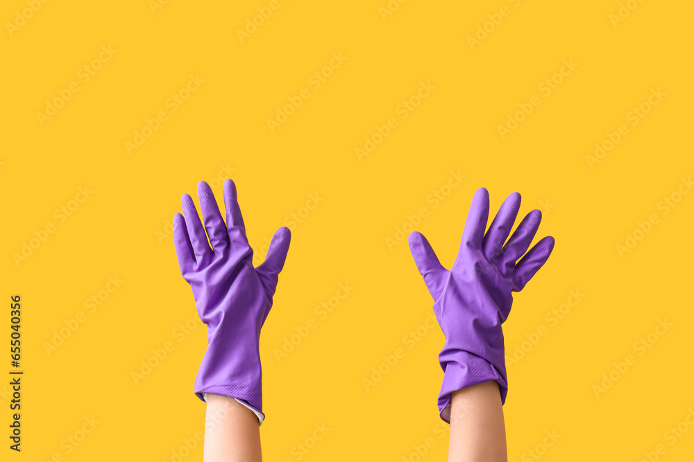 Woman in rubber gloves on yellow background