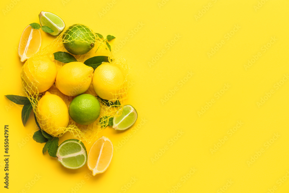 Mesh bag with fresh lemons and limes on yellow background