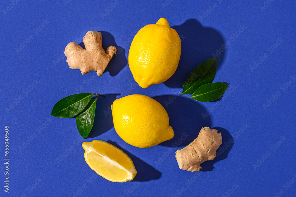 Fresh lemons and ginger roots on blue background